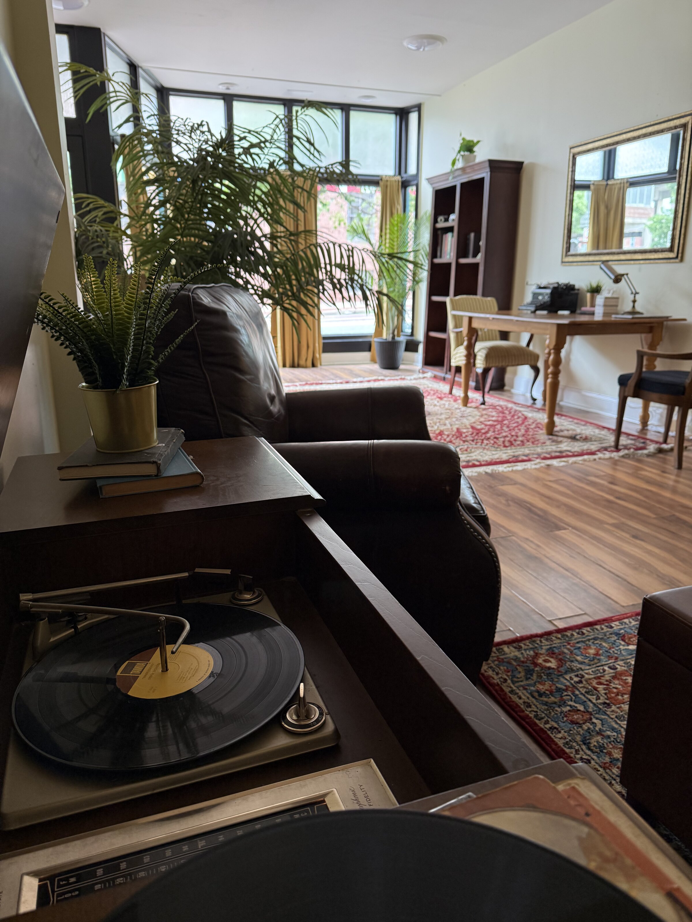 The parlor at 817 Howard — tall windows, plants, instruments